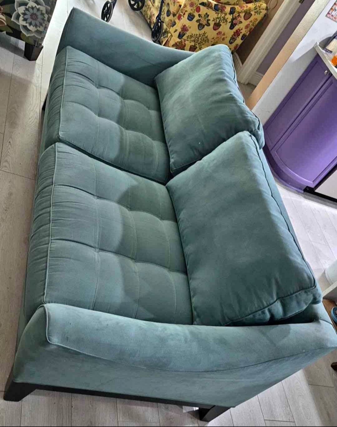 Teal tufted loveseat after cleaning