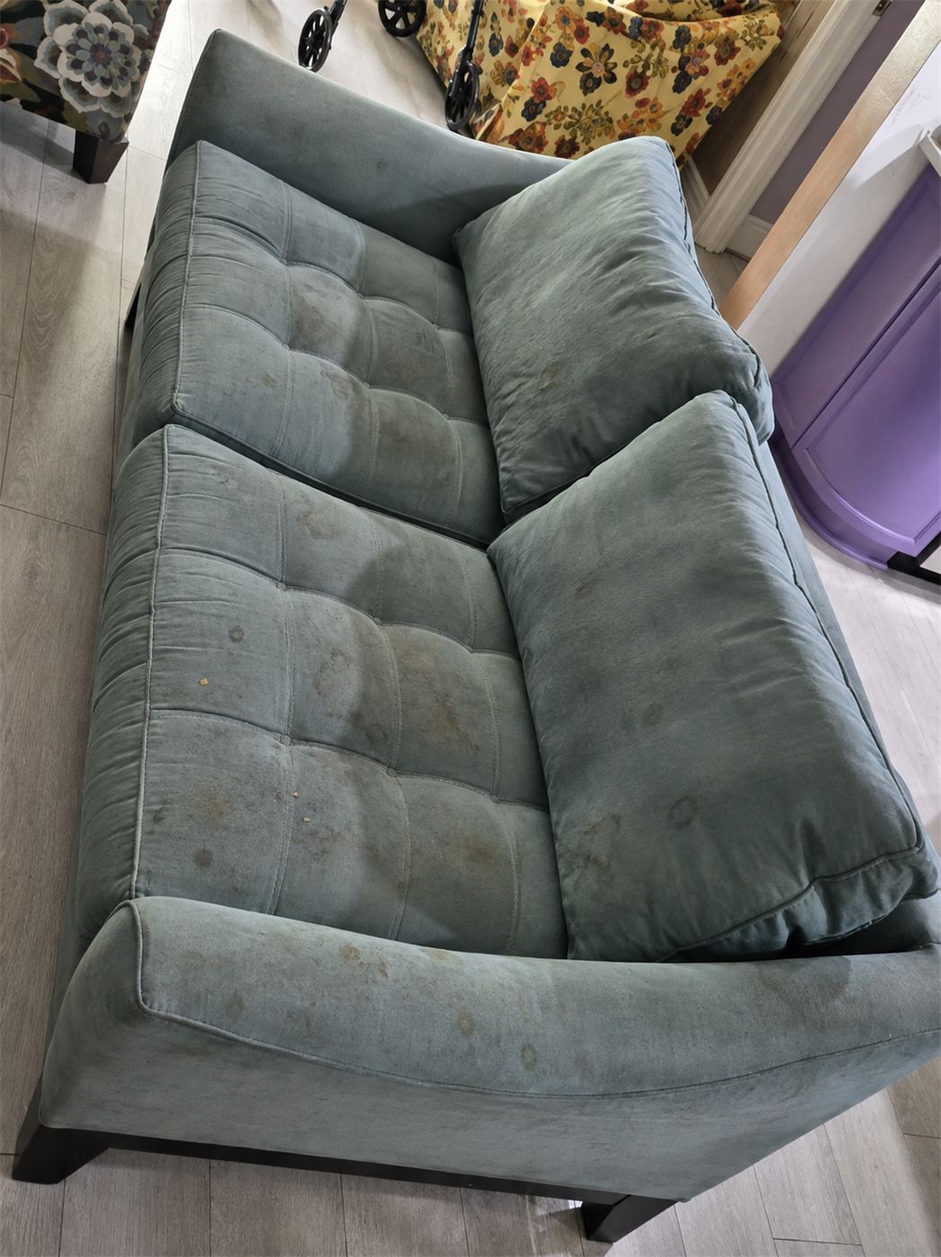 Teal tufted loveseat before cleaning